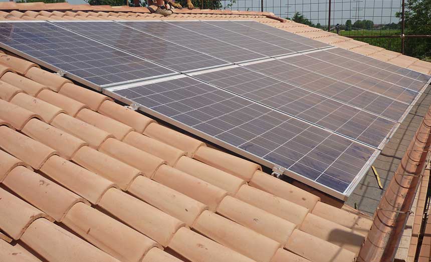 Pannelli fotovoltaici su un tetto in coppi, pianura sullo sfondo
